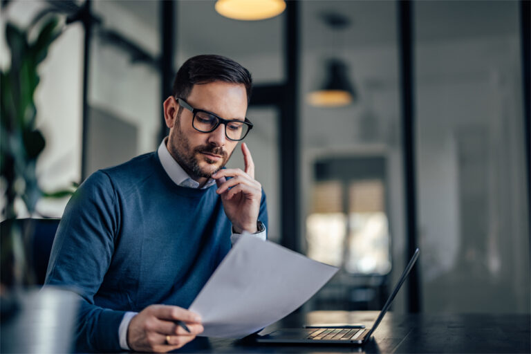 Portrait of a businessman, looking at one document, reading.