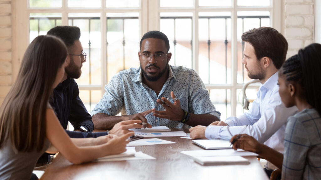 Multinational millennial colleagues gather at office meeting